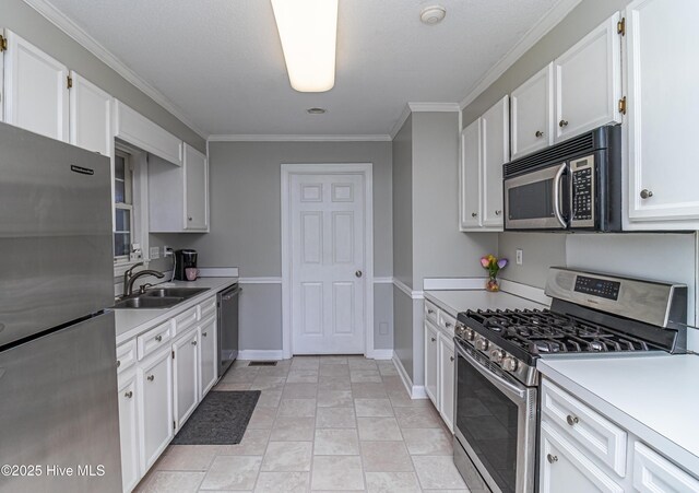 kitchen with crown molding, light countertops, a sink, white cabinets, and stainless steel appliances