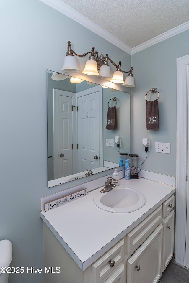 bathroom featuring crown molding, vanity, and a textured ceiling