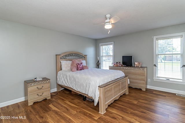 bedroom featuring baseboards, visible vents, ceiling fan, and dark wood-type flooring