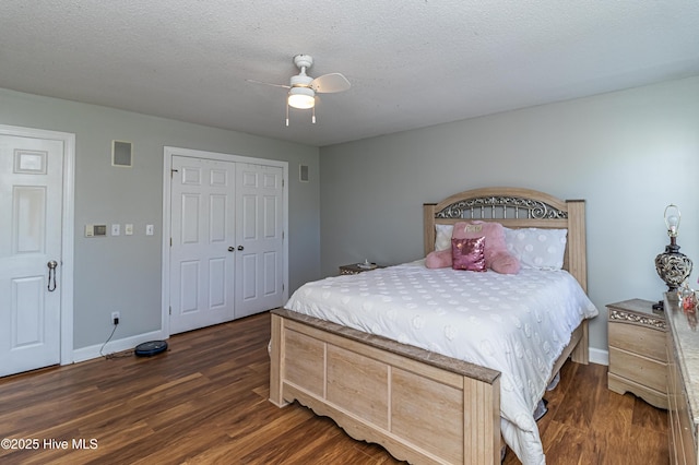 bedroom with ceiling fan, baseboards, dark wood-type flooring, visible vents, and a closet
