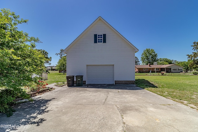 view of side of home featuring a garage, a yard, and driveway