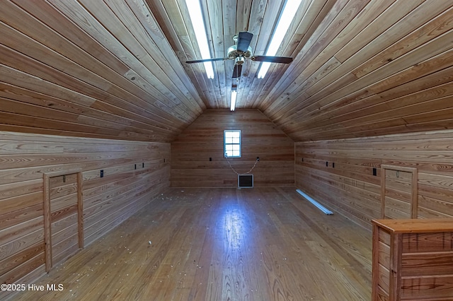 bonus room with ceiling fan, vaulted ceiling, wood walls, wooden ceiling, and wood-type flooring