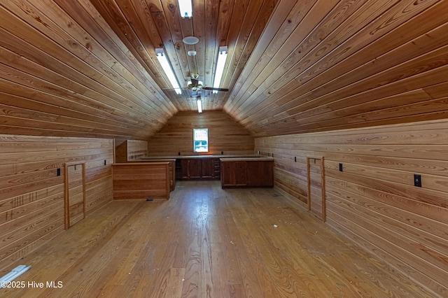 additional living space with light wood-style flooring, vaulted ceiling, wooden walls, and wooden ceiling
