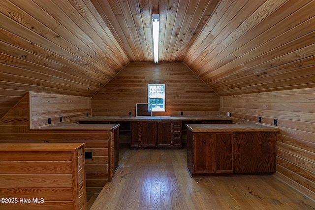 interior space with wooden walls, wood ceiling, hardwood / wood-style floors, and lofted ceiling