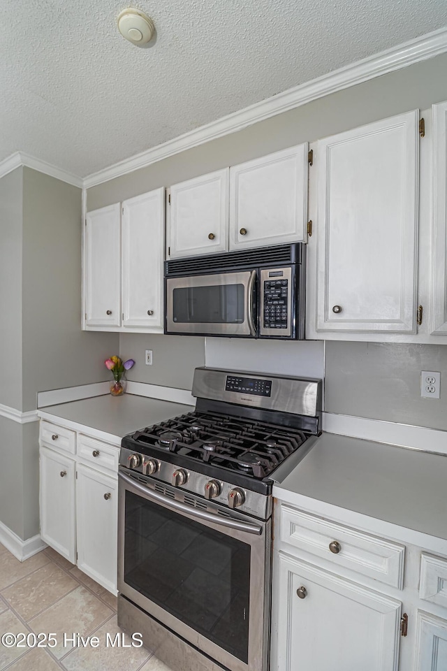 kitchen with light countertops, a textured ceiling, white cabinets, and stainless steel appliances