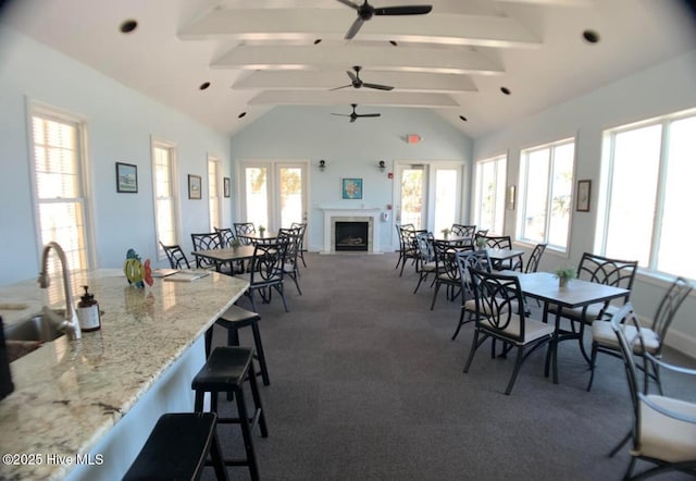 1626 Amberwood Dr SE, Bolivia, NC 28422 - carpeted dining space featuring a sink, plenty of natural light, beamed ceiling, ceiling fan, and a fireplace