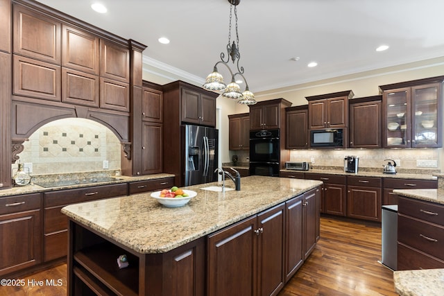 1626 Amberwood Dr SE, Bolivia, NC 28422 - kitchen with an island with sink, a sink, black appliances, tasteful backsplash, and hanging light fixtures