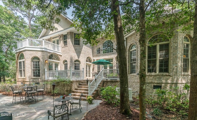 1626 Amberwood Dr SE, Bolivia, NC 28422 - rear view of house featuring brick siding, a patio, a balcony, and stairs