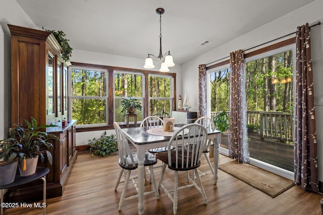 121 Pinewood Acres Dr, Powells Point, NC 27966 - dining space with light wood-style floors, visible vents, baseboards, and an inviting chandelier