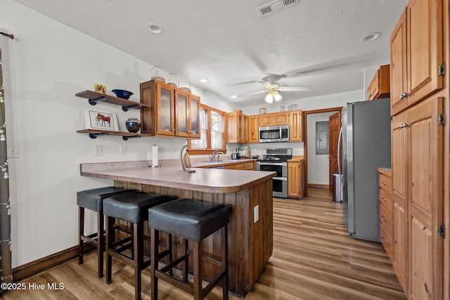 121 Pinewood Acres Dr, Powells Point, NC 27966 - kitchen featuring wood finished floors, a sink, stainless steel appliances, a peninsula, and visible vents