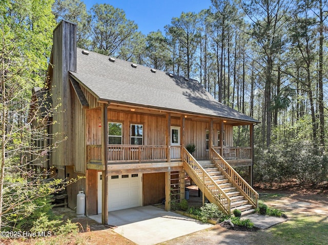 121 Pinewood Acres Dr, Powells Point, NC 27966 - rustic home with stairs, an attached garage, driveway, a porch, and roof with shingles