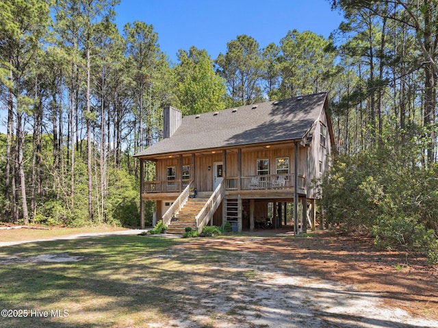 121 Pinewood Acres Dr, Powells Point, NC 27966 - view of front of home with roof with shingles, a carport, covered porch, stairs, and dirt driveway