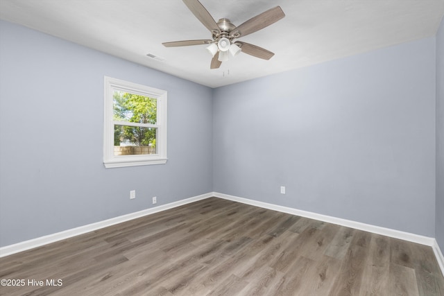 unfurnished room featuring visible vents, baseboards, ceiling fan, and wood finished floors
