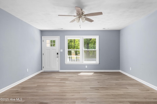 interior space featuring baseboards, a ceiling fan, and light wood-type flooring