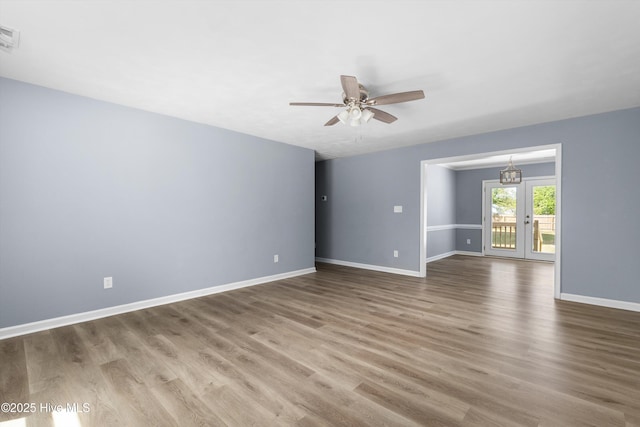 spare room with baseboards, ceiling fan, and wood finished floors