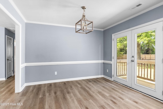 unfurnished dining area with wood finished floors, french doors, a chandelier, and visible vents