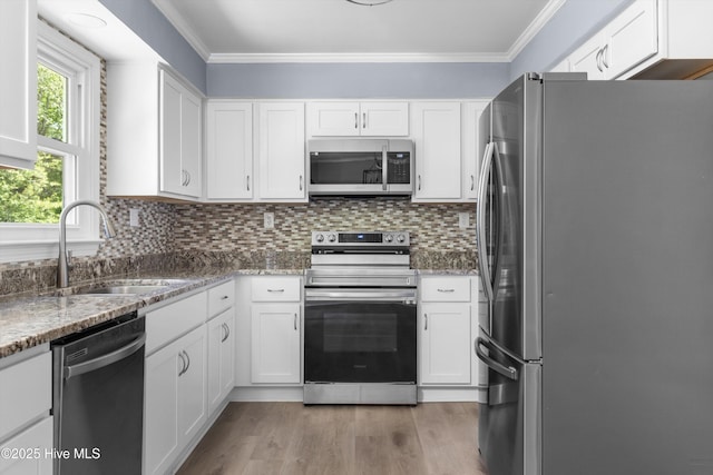 kitchen with crown molding, stainless steel appliances, white cabinets, and a sink