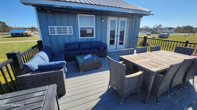 wooden terrace featuring a lawn, outdoor dining area, outdoor lounge area, and french doors