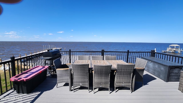 wooden deck with outdoor dining space and a water view