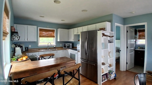 342 Owens Ln # 5, Columbia, NC 27925 - kitchen with a sink, white electric range oven, freestanding refrigerator, and white cabinetry