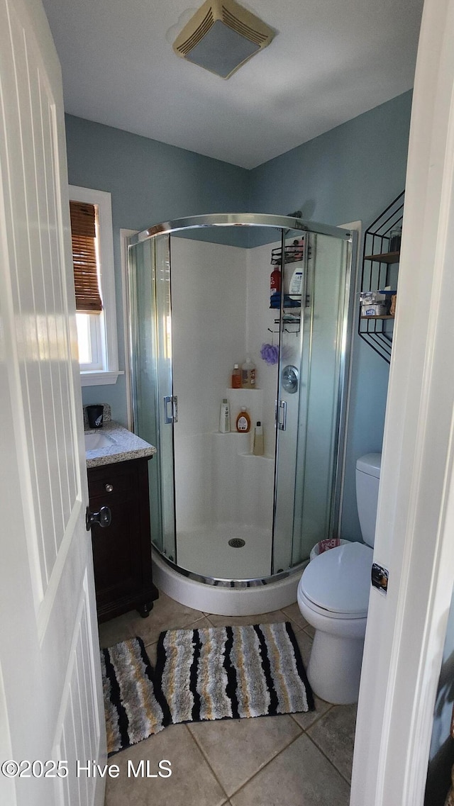 bathroom featuring tile patterned floors, toilet, visible vents, and a stall shower