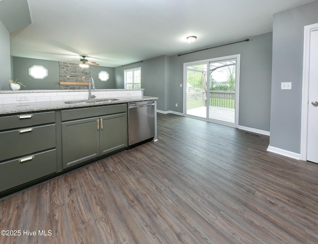 kitchen with dishwasher, baseboards, a sink, and dark wood-type flooring