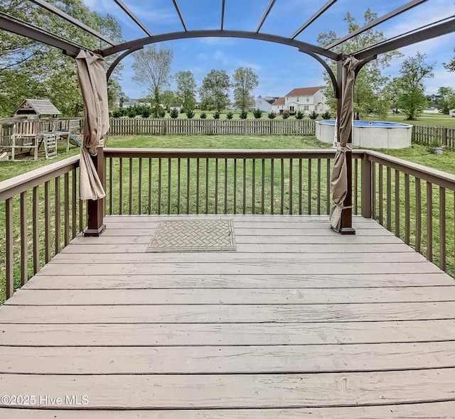 deck with a lawn and a fenced backyard
