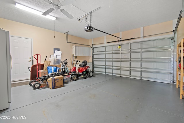 garage with a garage door opener, ceiling fan, and freestanding refrigerator