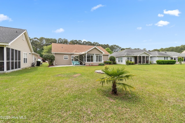back of property featuring a yard and a sunroom