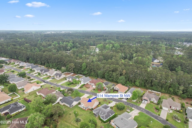 bird's eye view featuring a wooded view and a residential view