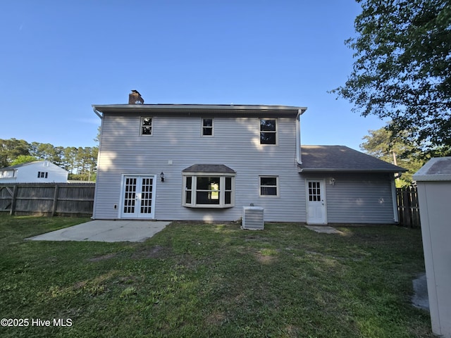 rear view of property with french doors, cooling unit, fence, a patio area, and a yard