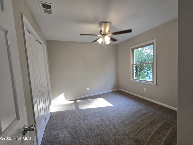 unfurnished bedroom featuring a ceiling fan, a closet, baseboards, carpet flooring, and visible vents