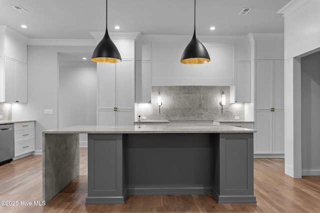 kitchen featuring visible vents, a kitchen island, recessed lighting, white cabinets, and tasteful backsplash