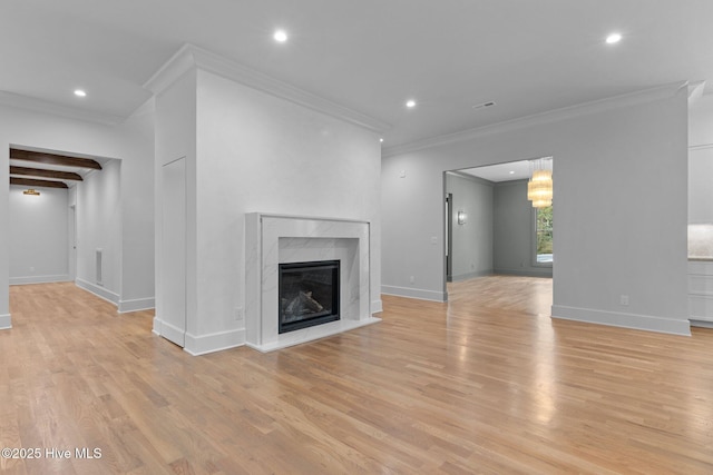 unfurnished living room featuring recessed lighting, ornamental molding, a fireplace, and light wood finished floors