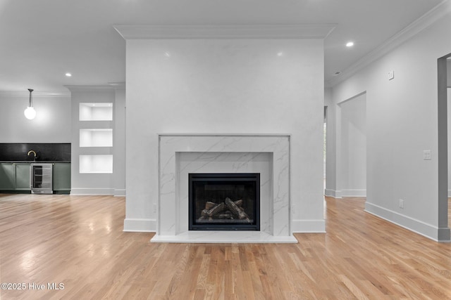 room details with built in shelves, baseboards, wood finished floors, wine cooler, and ornamental molding