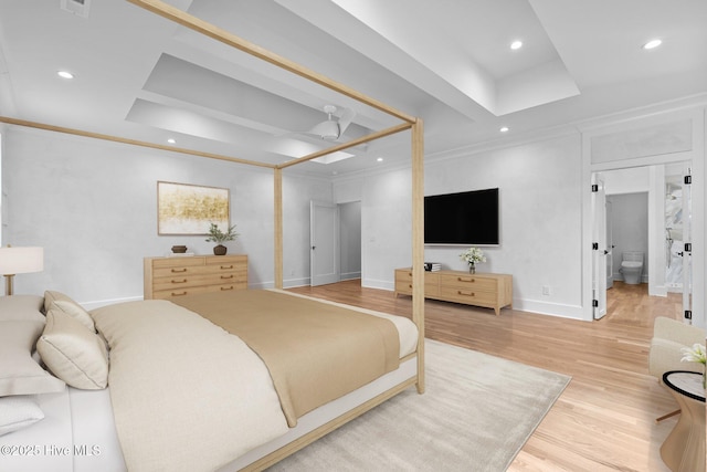 bedroom featuring light wood-style floors, recessed lighting, baseboards, and a tray ceiling