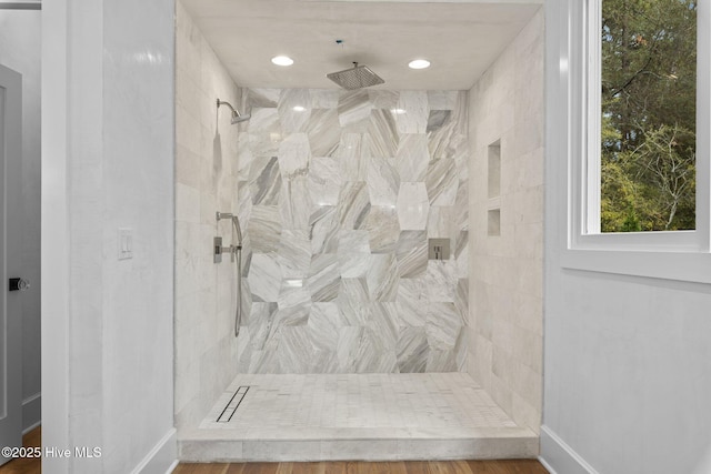 full bathroom featuring baseboards, recessed lighting, and a tile shower