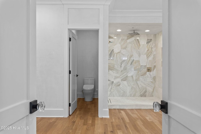 full bath with toilet, baseboards, a shower stall, and wood finished floors