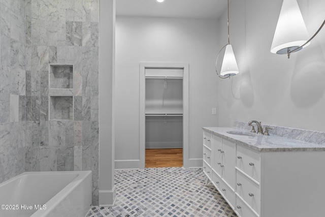 full bathroom featuring vanity, baseboards, tile patterned floors, and a spacious closet