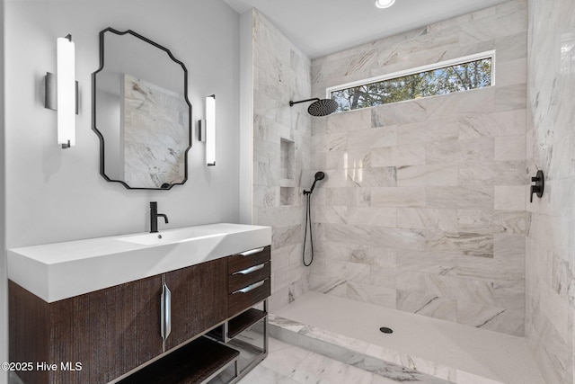 full bathroom featuring tiled shower, marble finish floor, and vanity