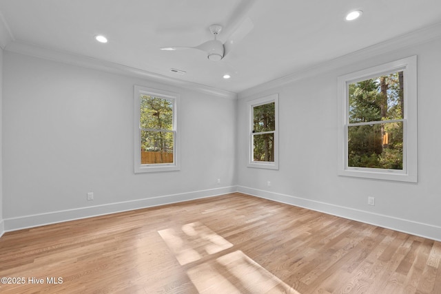 empty room featuring crown molding, baseboards, plenty of natural light, and visible vents
