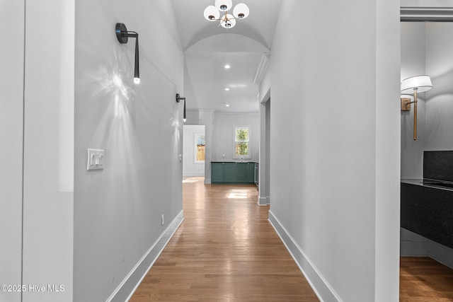 hallway featuring baseboards, ornamental molding, wood finished floors, and recessed lighting