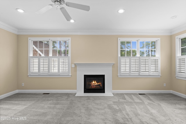 unfurnished living room with ornamental molding, a healthy amount of sunlight, and carpet floors