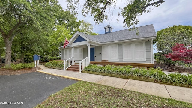 bungalow-style house with roof with shingles and covered porch