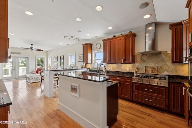 1605 Mackerel Ln Unit 2, Carolina Beach, NC 28428 - kitchen with stainless steel gas cooktop, plenty of natural light, wall chimney range hood, tasteful backsplash, and recessed lighting