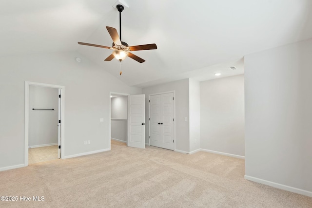 unfurnished bedroom featuring visible vents, ceiling fan, baseboards, vaulted ceiling, and light carpet