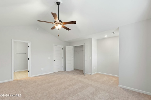unfurnished bedroom featuring light colored carpet, vaulted ceiling, baseboards, visible vents, and a ceiling fan