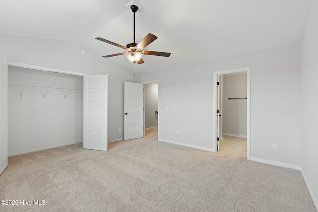 unfurnished bedroom with a closet, lofted ceiling, carpet floors, and baseboards