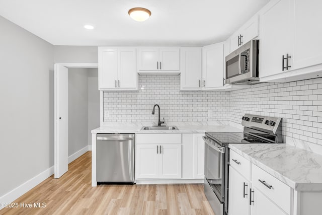 6203 Lynette Cir, Fayetteville, NC 28314 - kitchen with appliances with stainless steel finishes, a sink, light wood finished floors, baseboards, and white cabinets