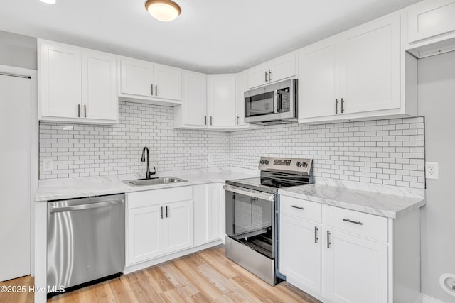 6203 Lynette Cir, Fayetteville, NC 28314 - kitchen with appliances with stainless steel finishes, a sink, white cabinetry, and light stone counters